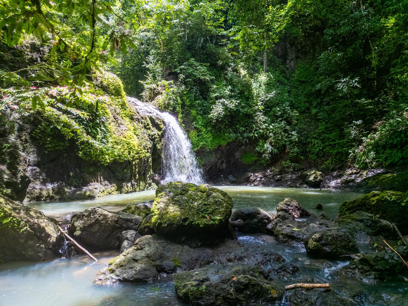 A waterfall and pool of green water on the trails of Manuel Antonio Estates